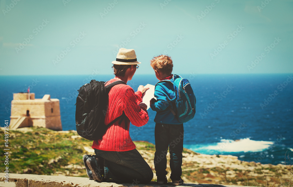 family travel -father and son looking at map in nature