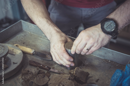 Engineer preparing a soil sample for a laboratory test in order to determine shear strength.  Soil being tested for mechanical characteristics before construction works.