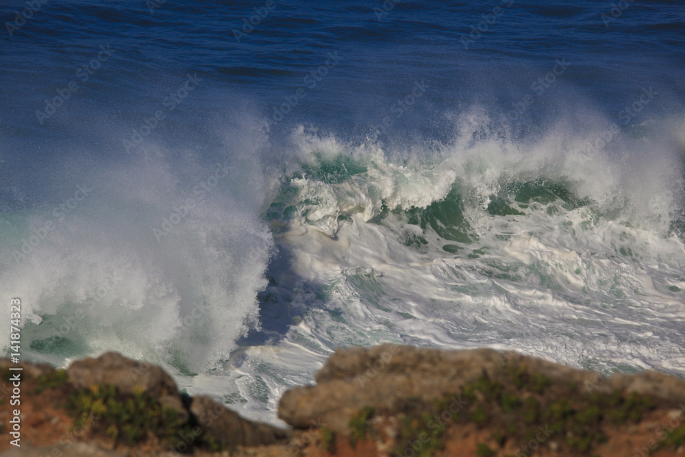 Obraz premium Marine wave breaks against offshore stone