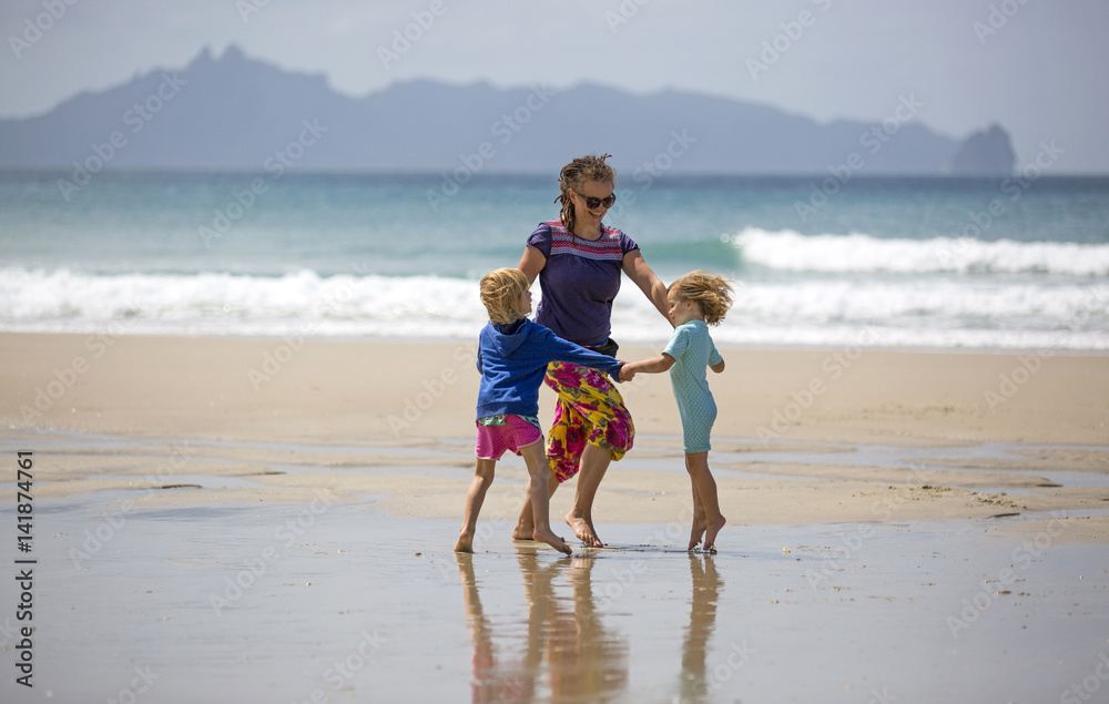 Happy woman and children on beach
Happy woman and children on beach