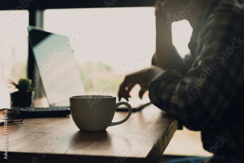 Foto Blur of the man working online at home or part time online jobs with coffee cup on the desk