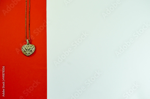 Heart-shaped pendant on a red strip on a white background