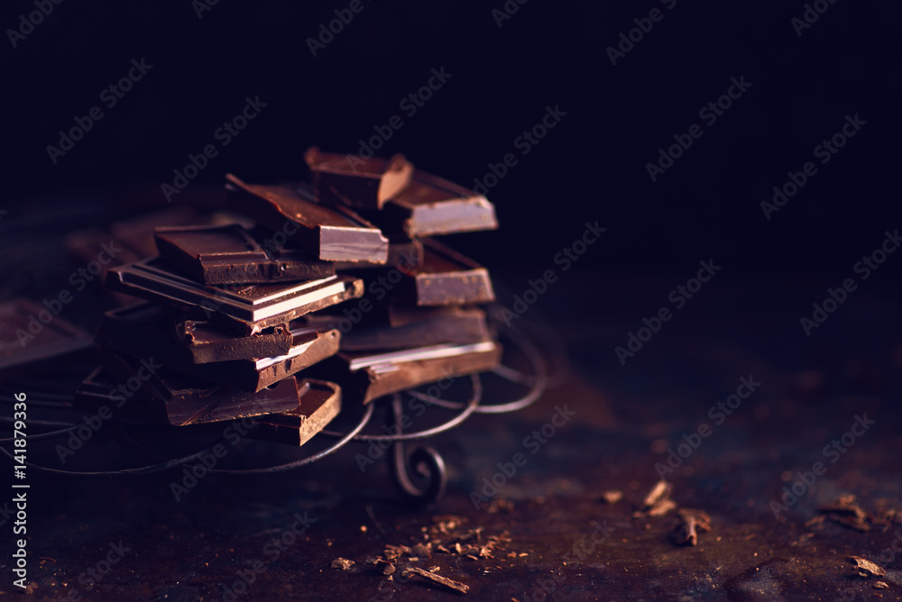 Dark chocolate pieces on dark table Dark chocolate pieces on dark table
