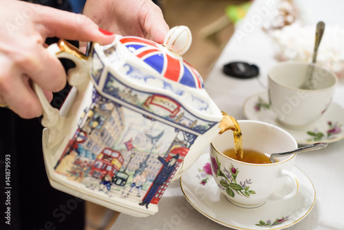 Tea poured into tea cup with British symbols photo