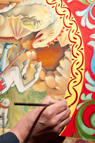 Hand of a sicilian cart painter while finishing some colored details. Workshop of the sicilian folkloric craftsmanship Rosso Cinabro, Ragusa Ibla © siculodoc