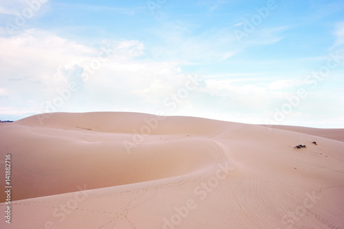 Fototapeta Naklejka Na Ścianę i Meble -  Desert landscape dunes in the afternoon with blue skies white clouds and nobody around, Vietnam asia.