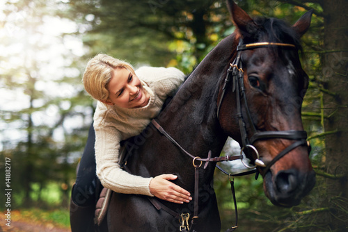 Woman patting her horse on the neck