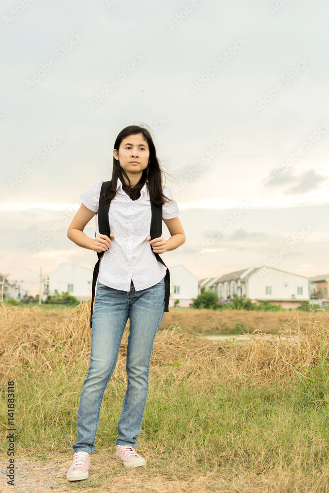 young traveler woman walking along country road. young traveler woman walking along country road.