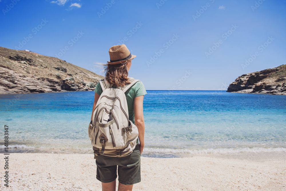 Woman traveler looking at the sea, travel and active lifestyle concept