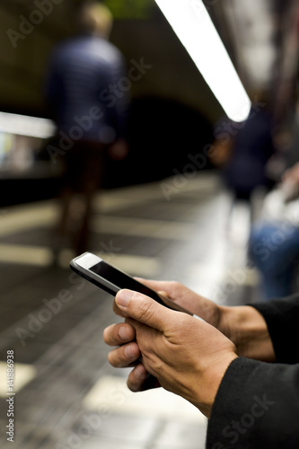 man using smartphone in underground station
