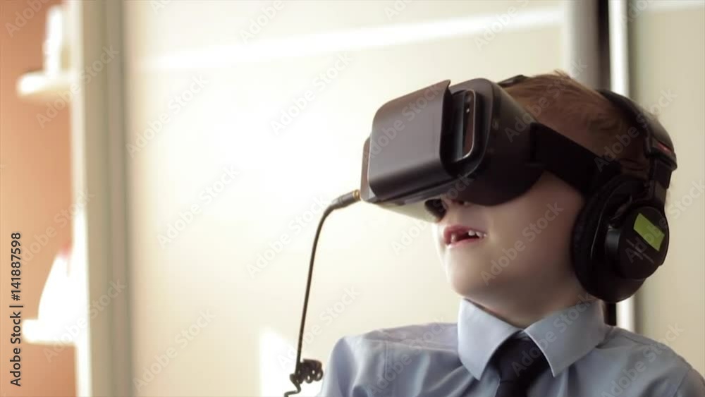 Little boy use virtual reality headset helmet, he very impressed Little boy use virtual reality headset helmet, he very impressed