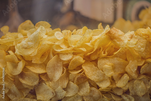 A lot of potatoes chips. Yellow salted potato chips as background. Chips texture.