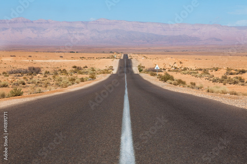 route droite au milieu d'un désert de sable 