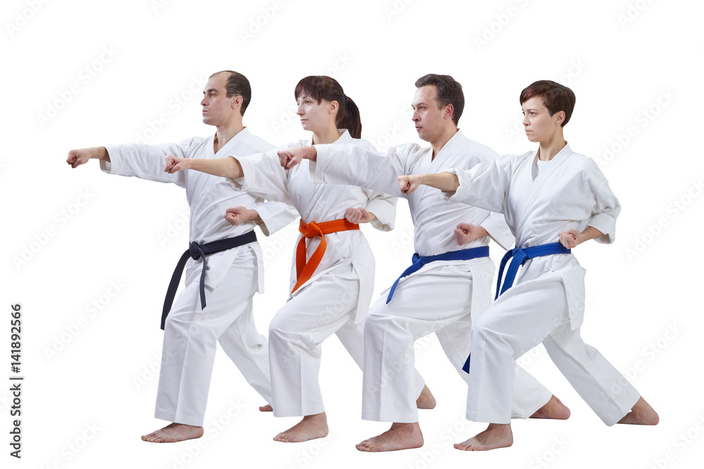 On a white background the athletes with different colors of belts are beating punch arm On a white background the athletes with different colors of belts are beating punch arm