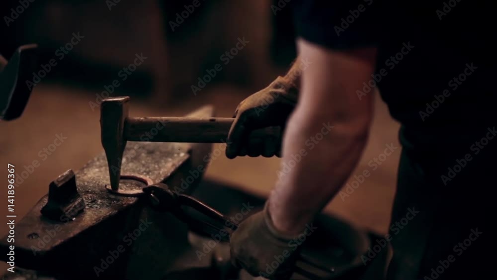 Two man with hammers making the horseshoe together. Blacksmith in apron at workplace, using the hot metals. Two man with hammers making the horseshoe together. Blacksmith in apron at workplace, using the hot metals.