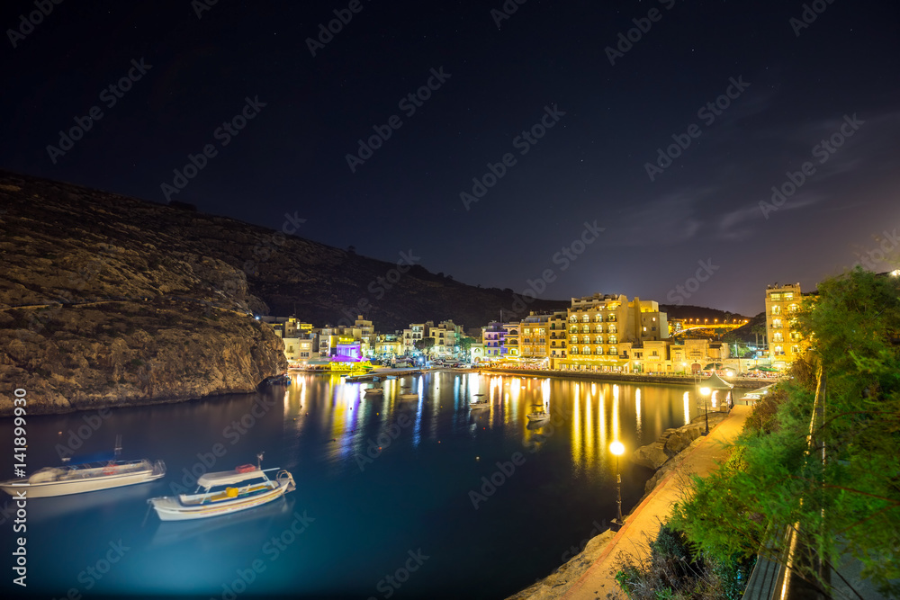 Xlendi, Gozo - Beautiful aerial view over Xlendi Bay by night with restaurants, boats and busy night life on the Island of Gozo