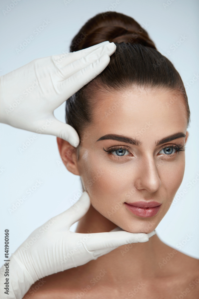 Facial Beauty. Hands In Gloves Touching Woman's Face