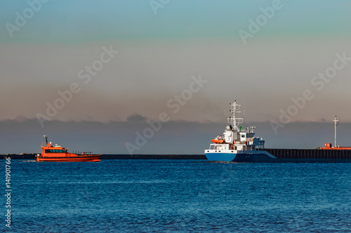 Blue cargo ship leaving Riga and entering Baltic sea © InfinitumProdux