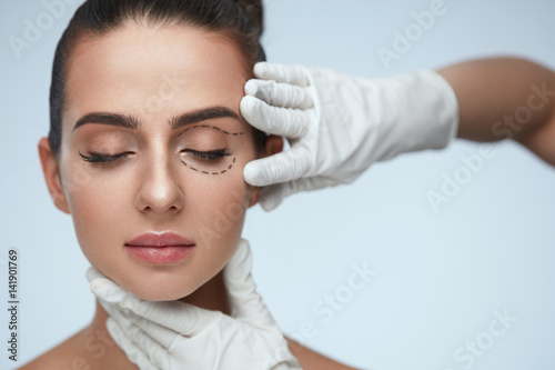 Closeup Of Beautician Hands Touching Young Female Patient Face photo