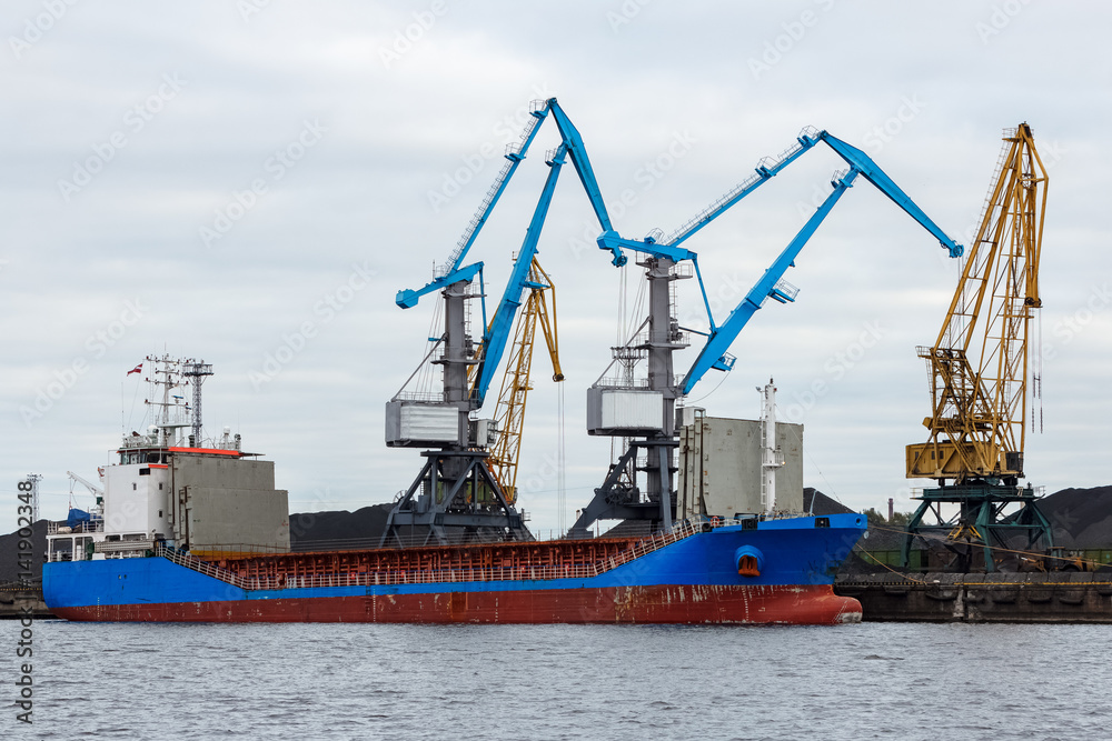 Blue cargo ship loading in the port of Riga, Europe Blue cargo ship loading in the port of Riga, Europe