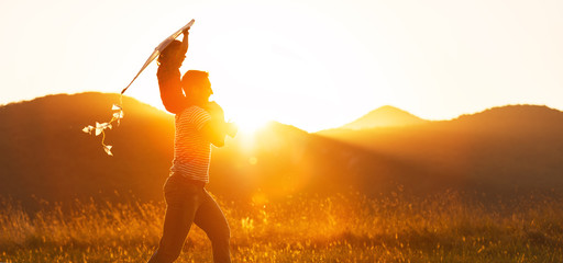 Happy father's day! Child girl and dad with a kite on nature in summer