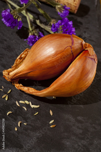 Close up of a shallot with fennel seeds and purple flowers and cork