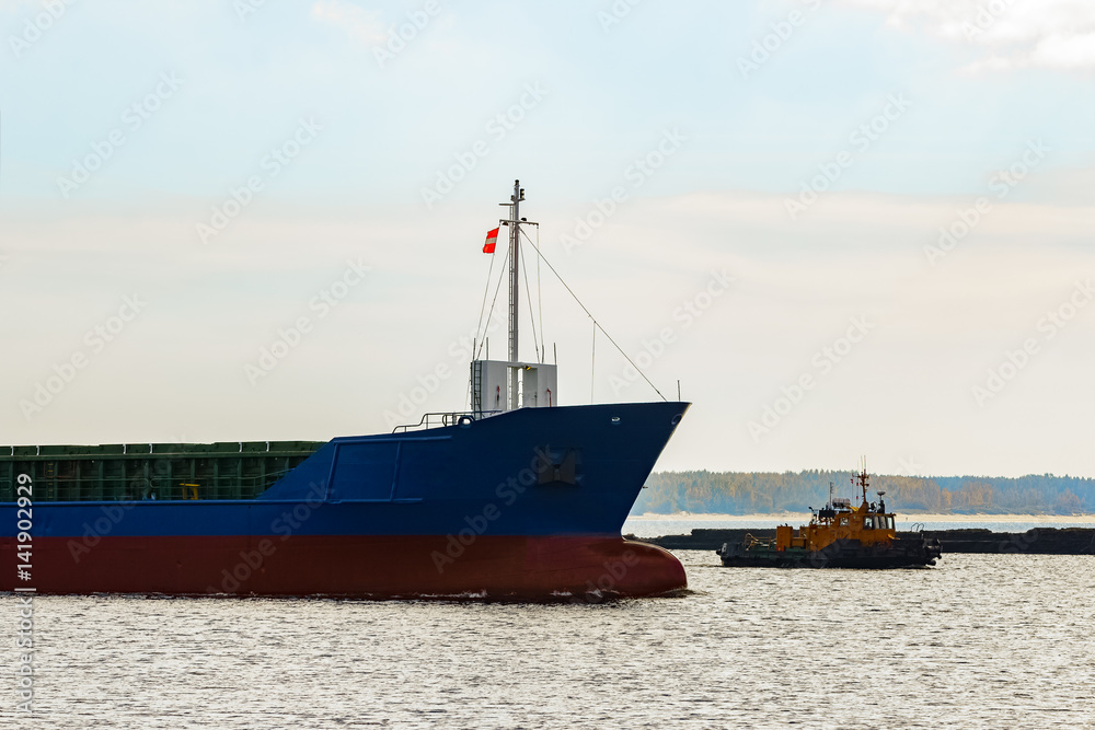 Blue cargo ship's bow leaving the port of Riga