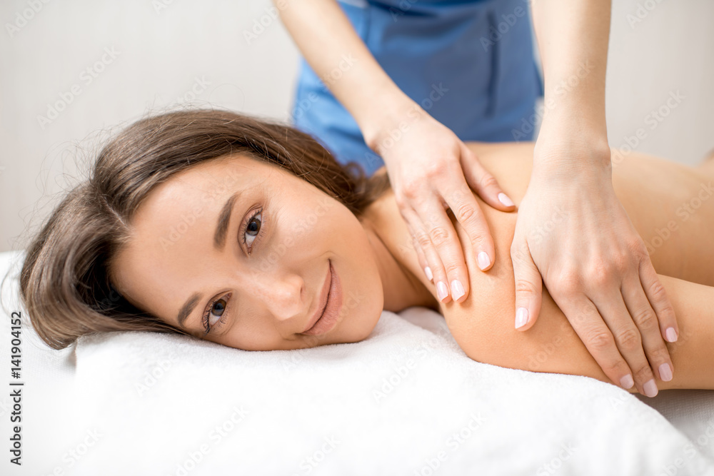 Beautiful woman getting professional massage on her back lying on the couch in the Spa