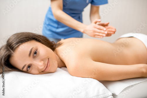 Beautiful woman getting professional massage on her back lying on the couch in the Spa