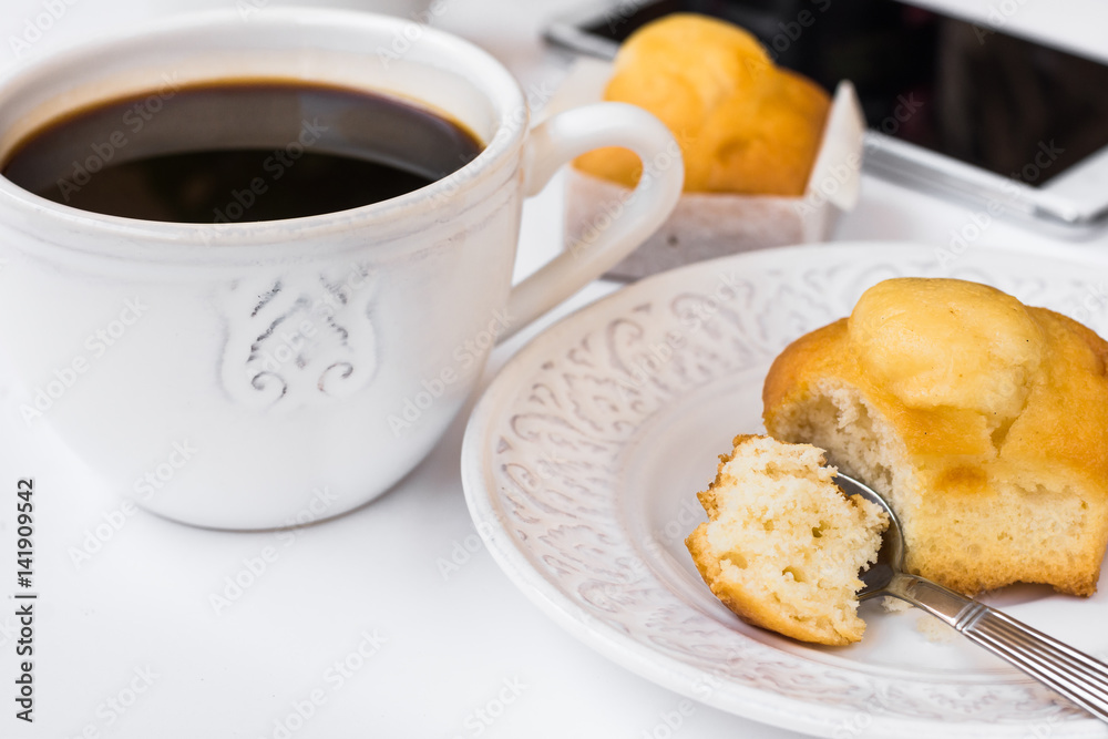White desktop with cup of coffee, plate with muffin and smartphone, styled image for social media, female blogging White desktop with cup of coffee, plate with muffin and smartphone, styled image for social media, female blogging