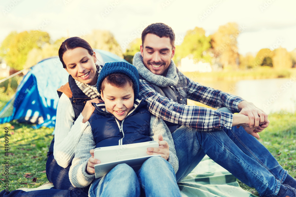 happy family with tablet pc and tent at camp site