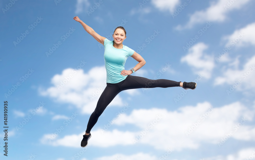 happy sporty young woman jumping in blue sky happy sporty young woman jumping in blue sky