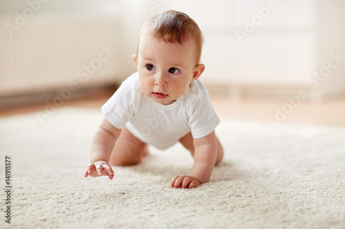 little baby in diaper crawling on floor at home