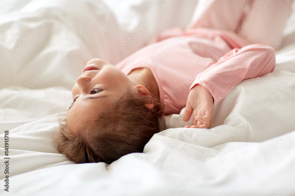 happy little girl lying in bed at home happy little girl lying in bed at home
