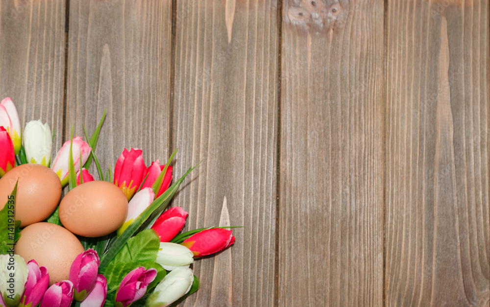 Tulips and eggs on a wooden background