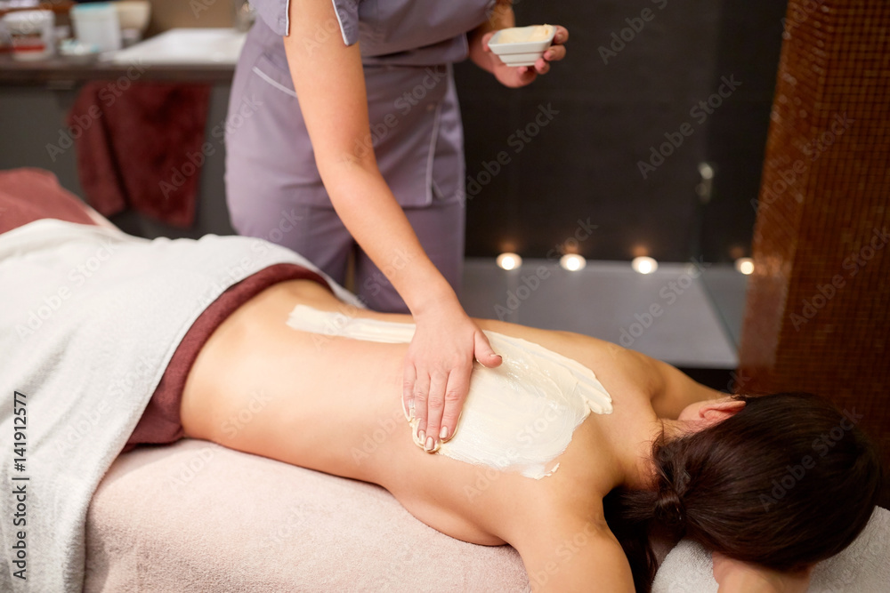 Fototapeta premium woman having back massage with cream at spa