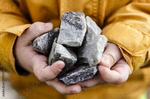 grey stones in cute small child hands