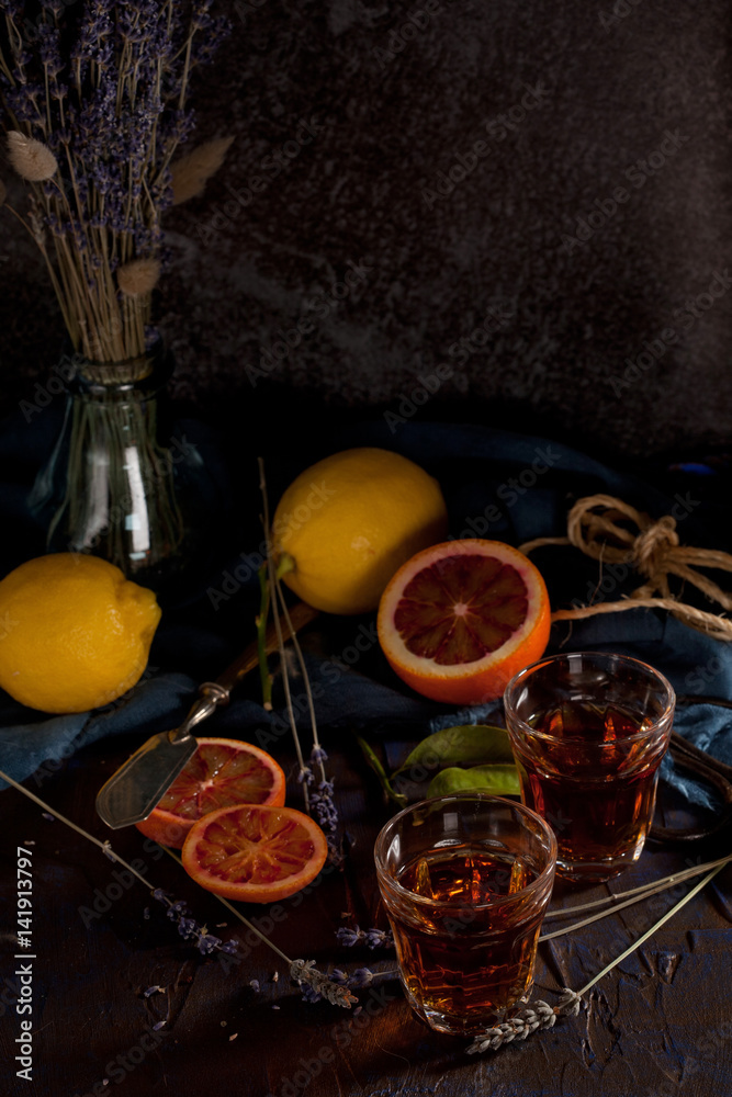 Obraz premium Rustic still life with tea or liqueur drink, citruses and lavender