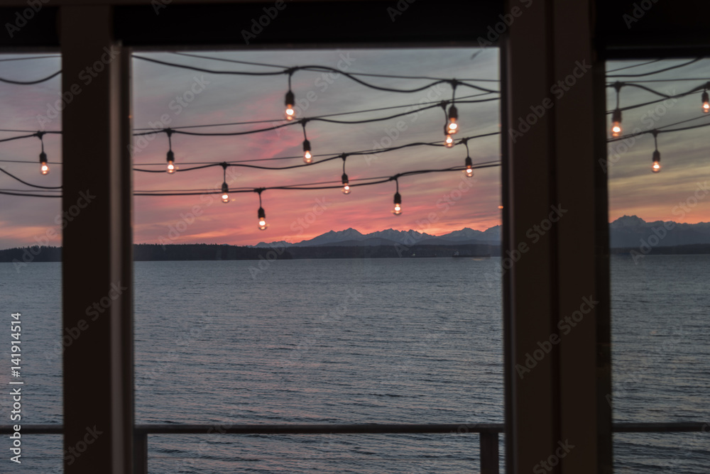 Pink Sunset over the sea and mountains from window