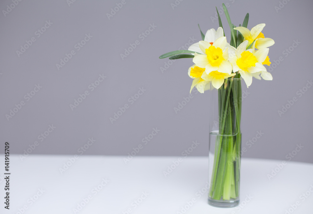 Fototapeta premium Posy of bright yellow daffodils on white wooden table