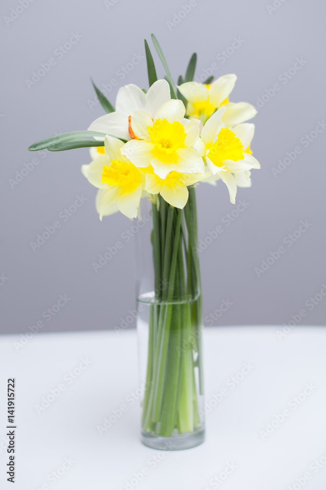 Posy of bright yellow daffodils on white wooden table Posy of bright yellow daffodils on white wooden table