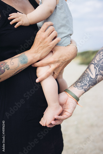 famille balade à la plage avec bébé parents tatoués photo