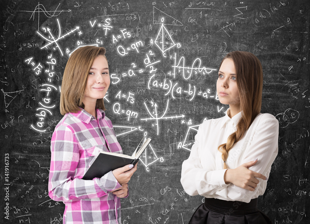 Fototapeta premium Two girls and formulas on blackboard