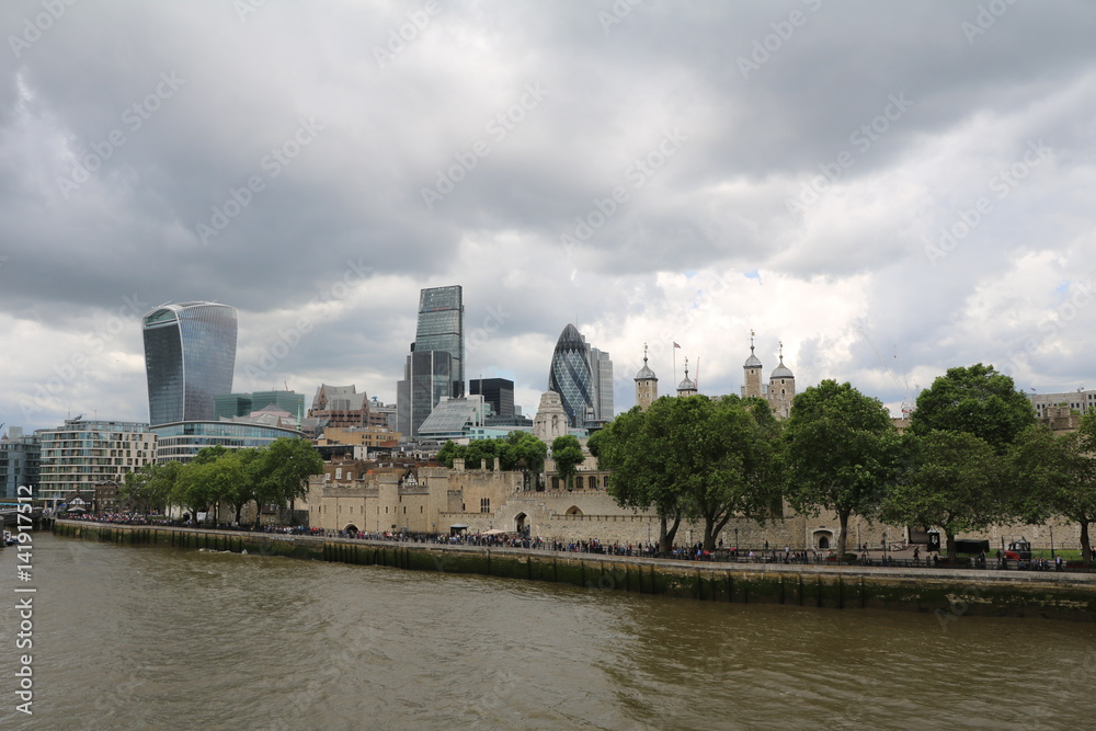 London under grey clouds at the River Thames view from Tower Bridge, United Kingdom