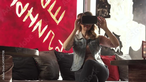 woman uses a virtual reality glasses in cafe photo