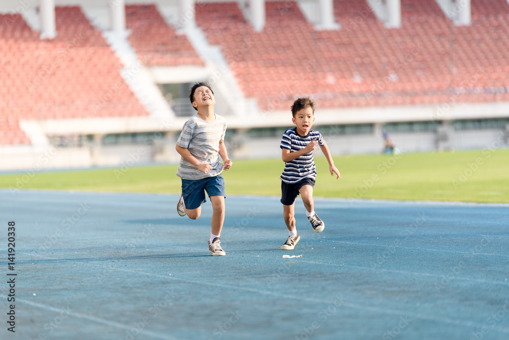 Fototapeta premium Boy running on the blue track