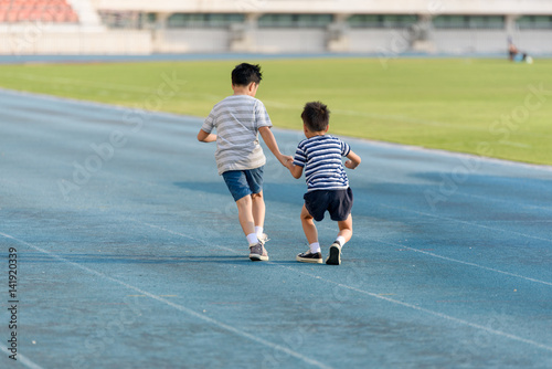 Boy help each other on blue track after fall
