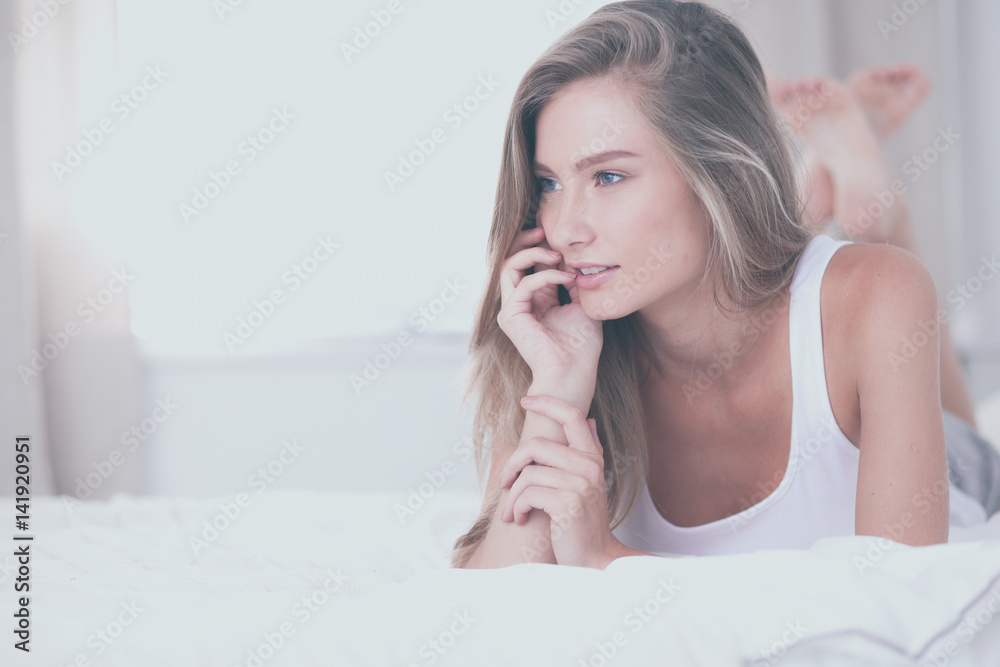 Pretty woman lying down on her bed at home Pretty woman lying down on her bed at home