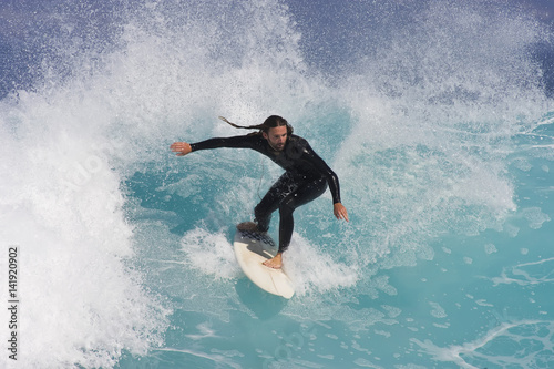 A Surfer rides a blue wave