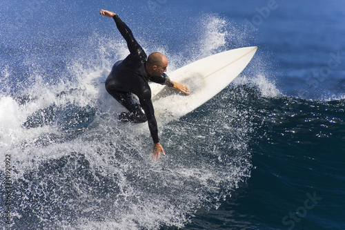 фотографія A Surfer carves a turn at the tip of the wave.